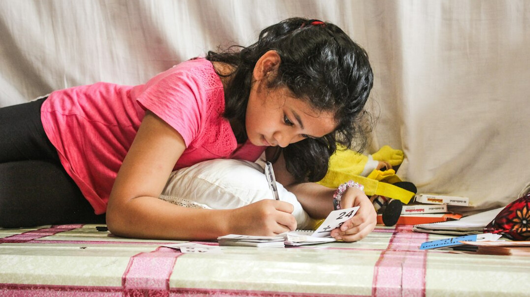 Mulher brasileira escrevendo em um caderno em uma mesa iluminada por luz natural
