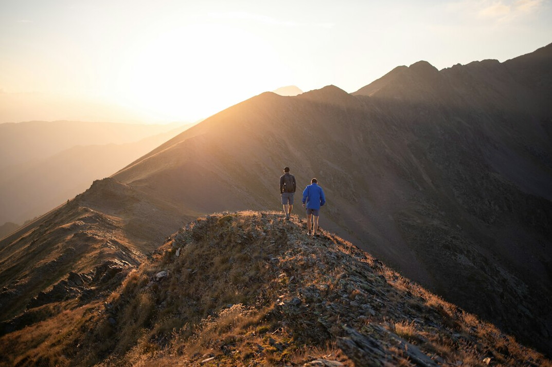 person climbing mountain at sunrise